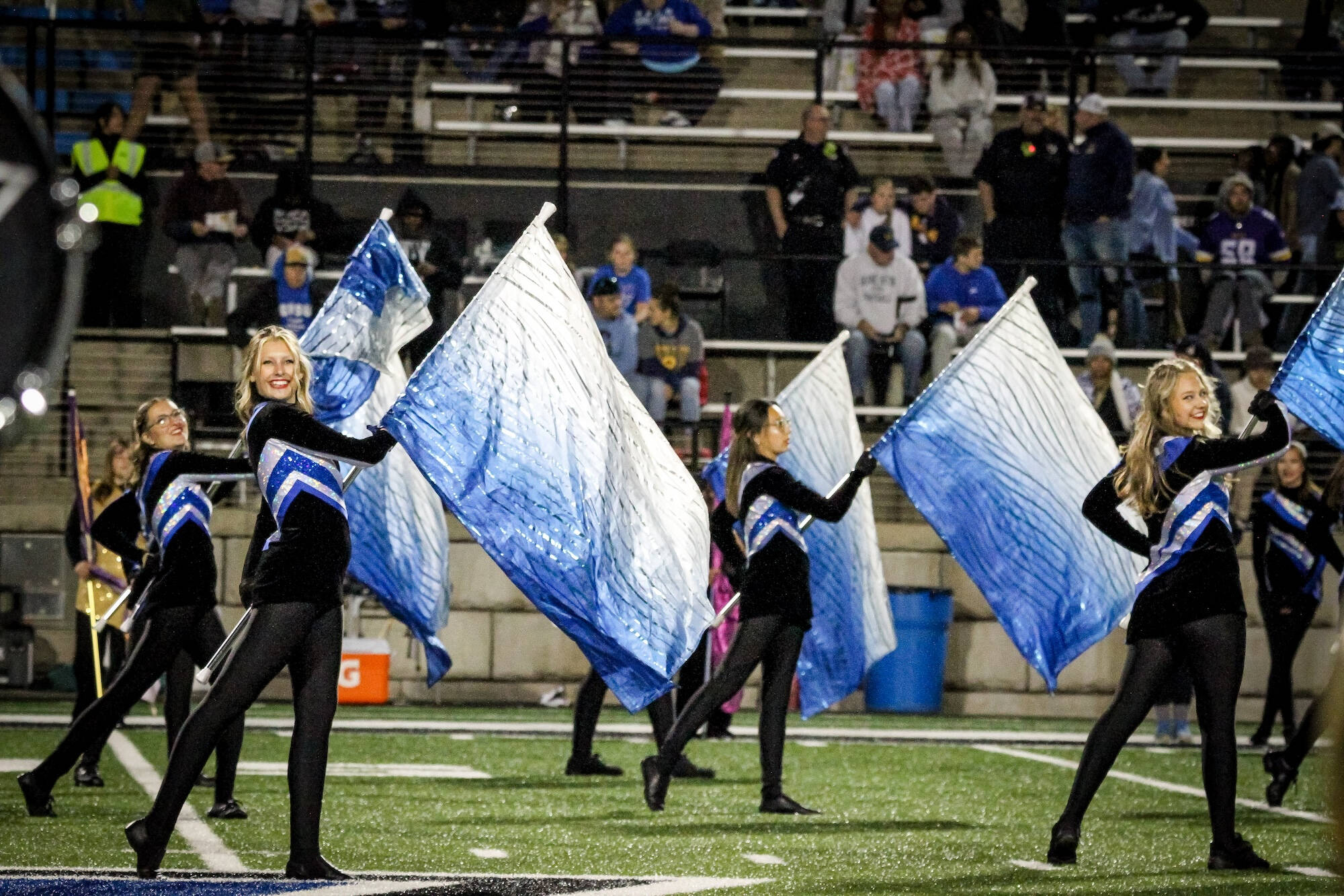 color guard members holding their flag on their left with their right foot pointed out to the side